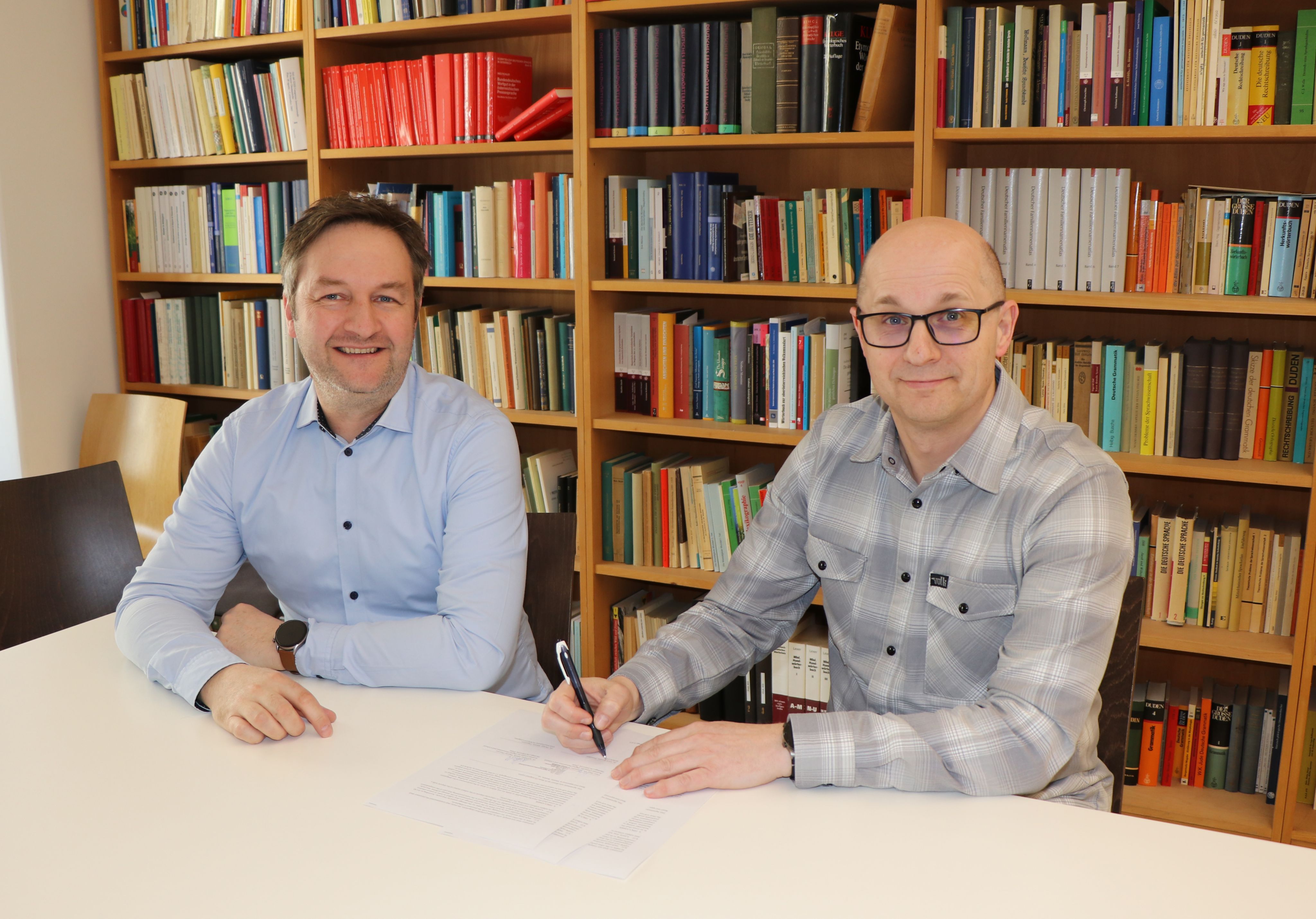 Photograph of the parties signing the contract