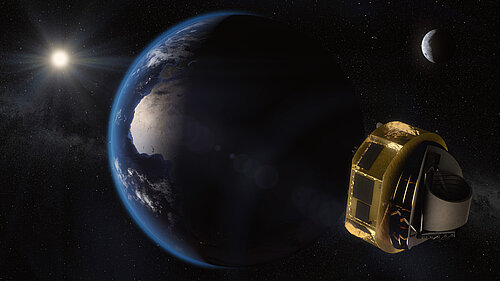 The image shows Earth from space, illuminated by the Sun, with the Moon and stars visible in the background. In the foreground on the right, the gold-colored ARIEL space telescope is floating.