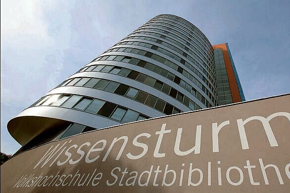 Blick auf den Wissensturm Linz, ein elliptisches Hochhaus im Volksgartenviertel in Linz, das neben der Volkshochschule auch die Stadtbibliothek Linz beheimatet
