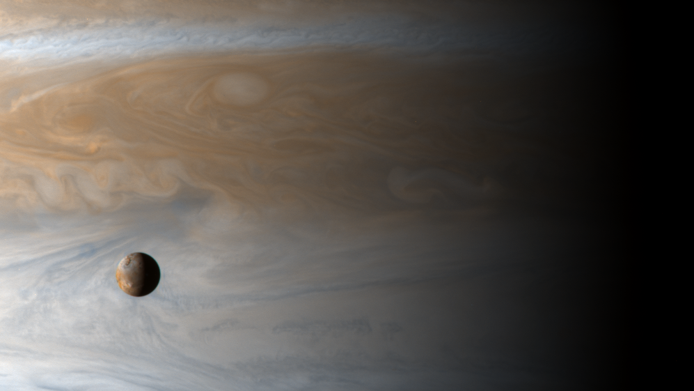 Dieses Bild zeigt den Mond Io im Orbit um Jupiter. Im großteil des Hintergrunds ist Jupiter zu sehen.