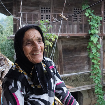 Romeyka-Sprecherin vor der typischen Holzarchitektur der Region © Thede Kahl