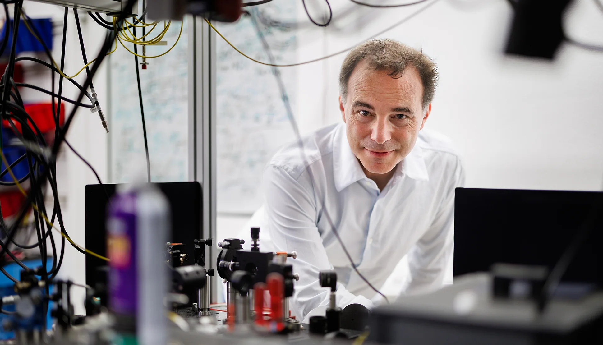 Markus Aspelmayer blickt in einem quantenphysikalischen Labor in die Kamera
