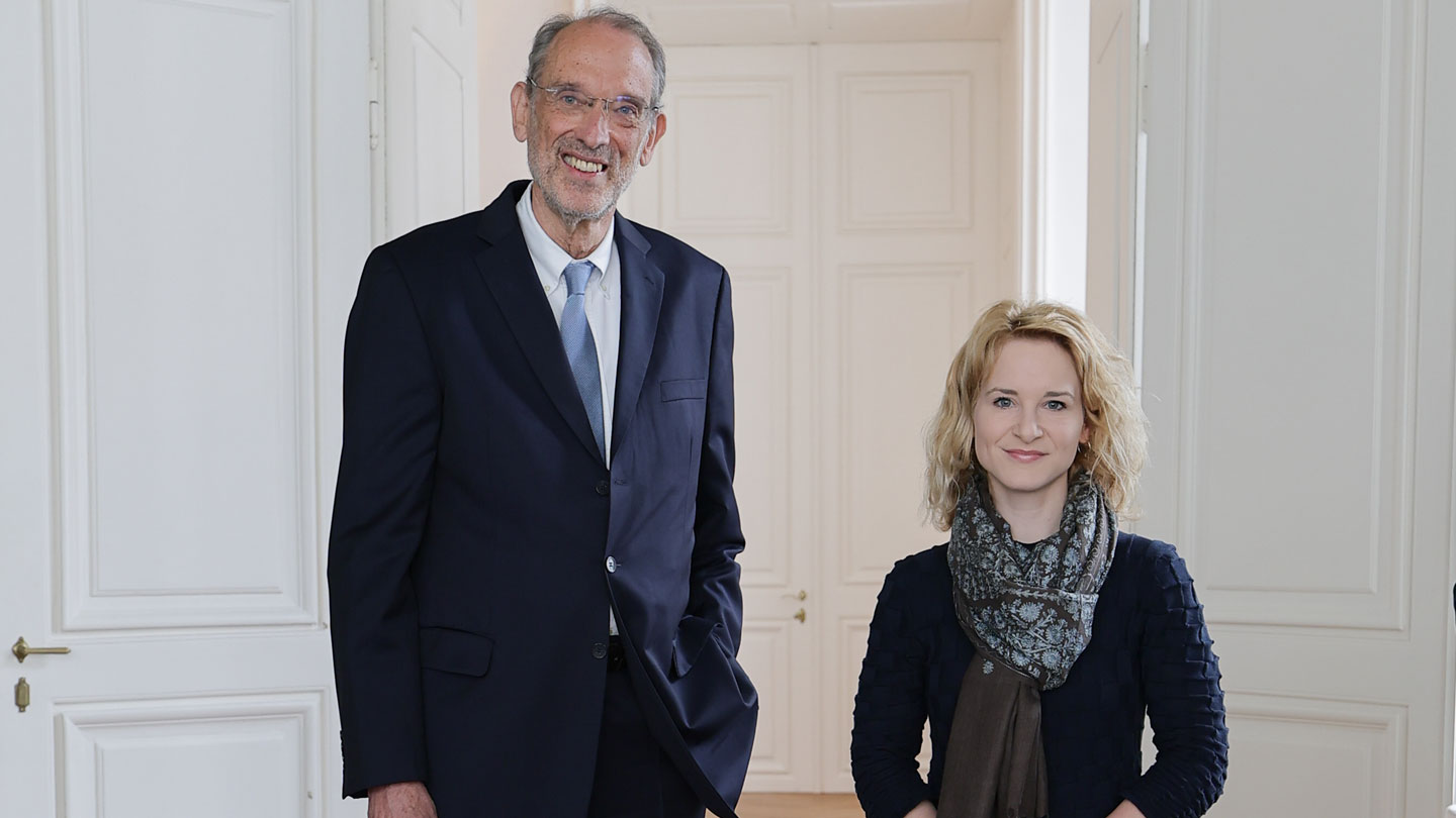 Eva-Maria Holzleitner und Heinz Faßmann stehen nebeneinander vor einem Saal 