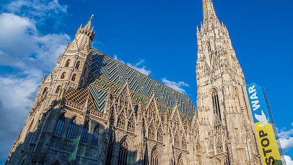 Ein Foto vom Wiener Stephansdom, an dessen Seite ein Plakat in den ukrainischen Nationalfarben und mit der Aufschrift "Stop the war" zu sehen ist. 
