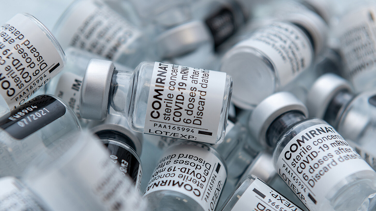 Ohne Impfstoff wäre die Coronapandemie kaum zu besiegen. Aufnahme einer Reihe von Impfstoff-Behältern