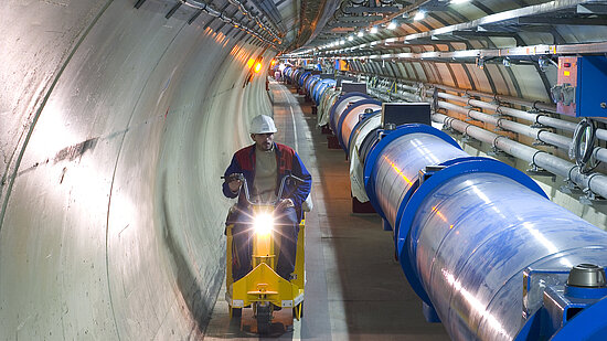 Foto: Arbeiter auf Fahrzeug in Tunnel von Teilchenbeschleuniger CERN