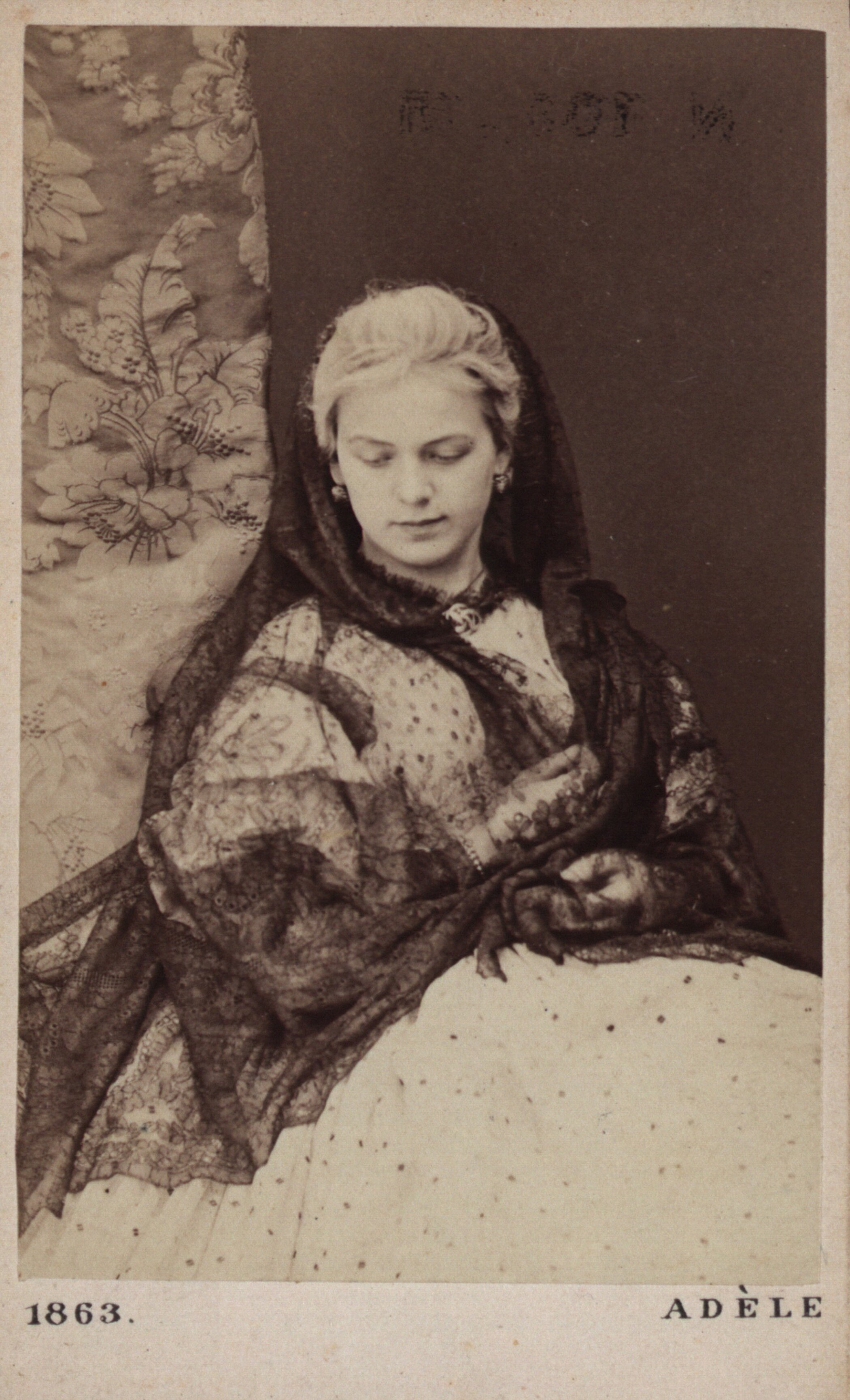 Portrait einer sitzenden Dame, sie trägt ein edles Kleid und blickt nach unten.