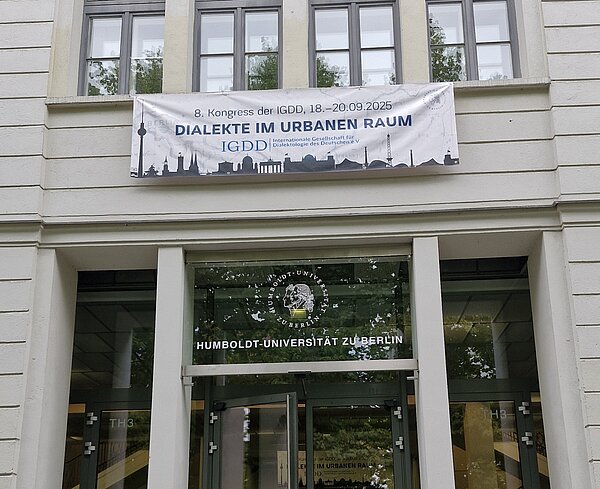 Der Eingang der Humboldt-Universität zu Berlin mit einem Banner, das die Konferenzgäste begrüßt.