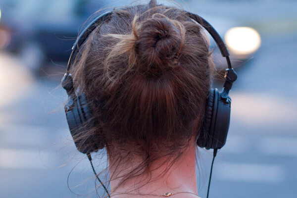 Woman seen from behind wearing headphones.