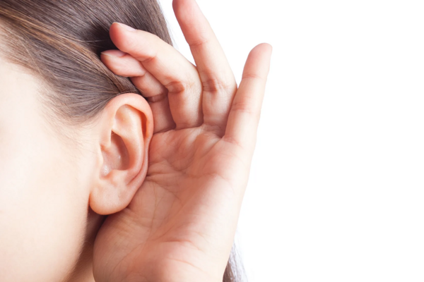 Close-up of a woman cupping her ear to listen intently.