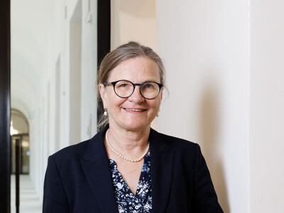 ÖAW-Vizepräsidentin Ulrike Diebold steht vor einem Arkadengang