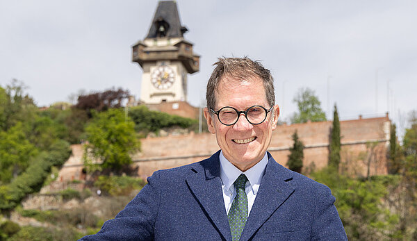 Foto von Giulio Superti-Furga vor dem Grazer Uhrturm
