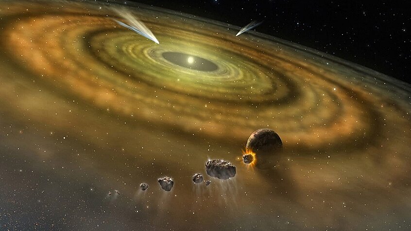A colorful artistic rendering shows the formation of a planetary system around a young star. Amid a vast, rotating disk of gas and dust, the first planets and asteroids are forming, while comets pass through the system.