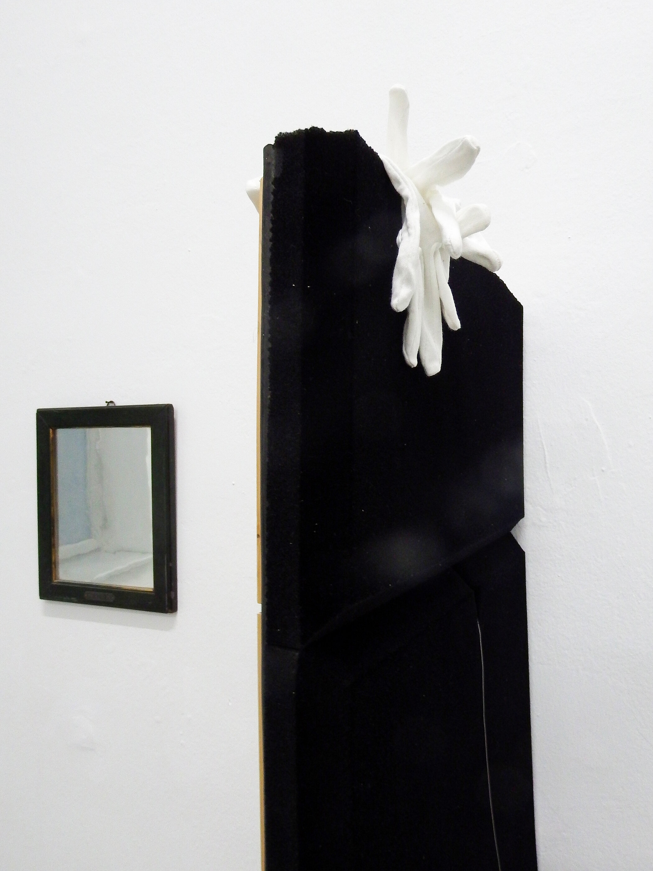 Ausstellungsansicht von Akustikschaum, weißen Handschuhen und einem alten Spiegel aus dem Phonogrammarchiv © Jasemin Khaleli