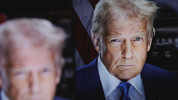 Donald Trump blickt mit einem zugekneiften Auge in die Kamera