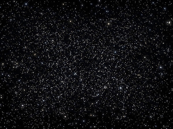Dichtes Sternenfeld vor schwarzem Weltraumhintergrund mit zahlreichen weiß, bläulich und gelblich leuchtenden Sternen unterschiedlicher Helligkeit.